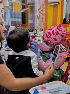 Madre cepillando los dientes de su bebé