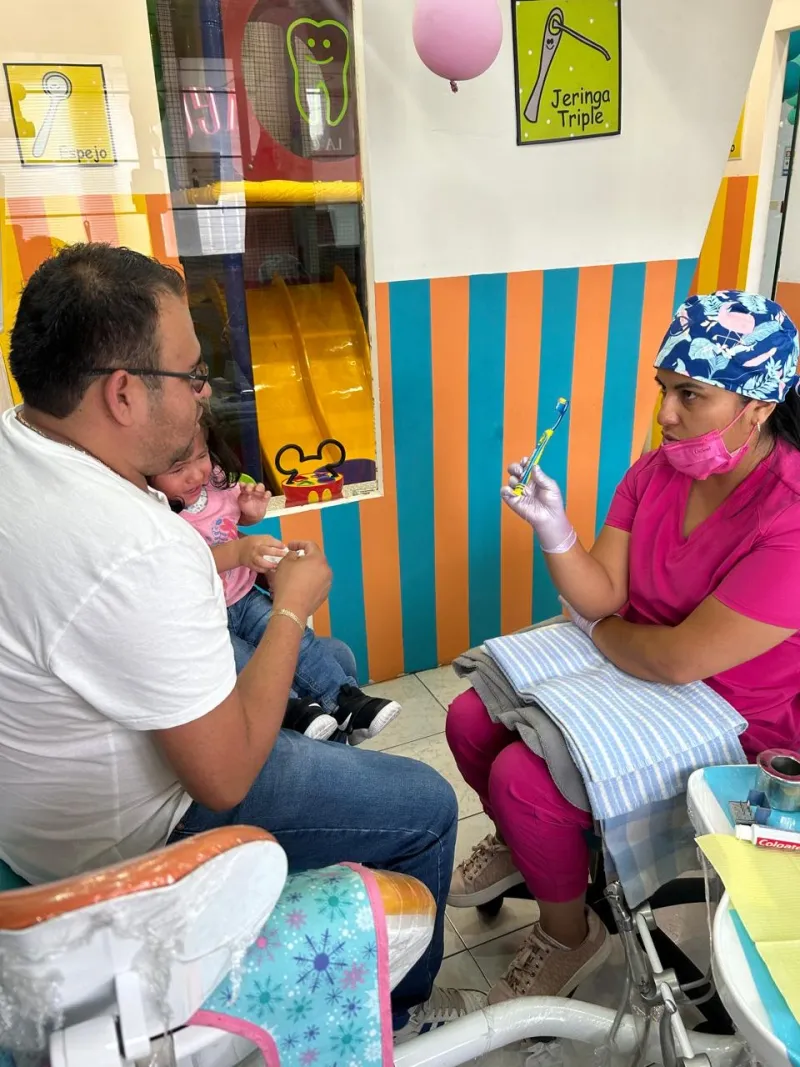Odontóloga enseñando higiene a un bebé